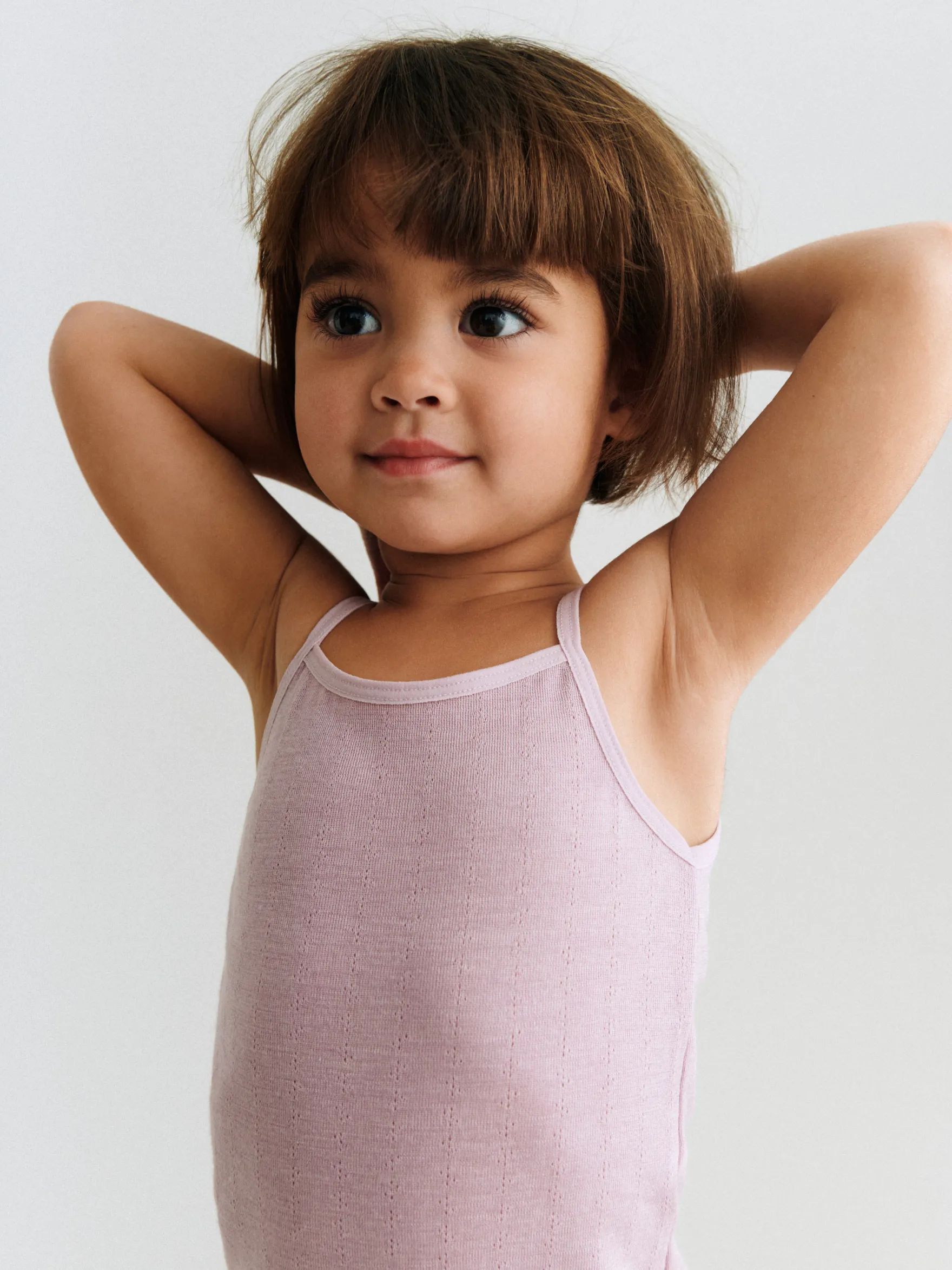 Body med stropper i merinould/silke med hulmønster til baby